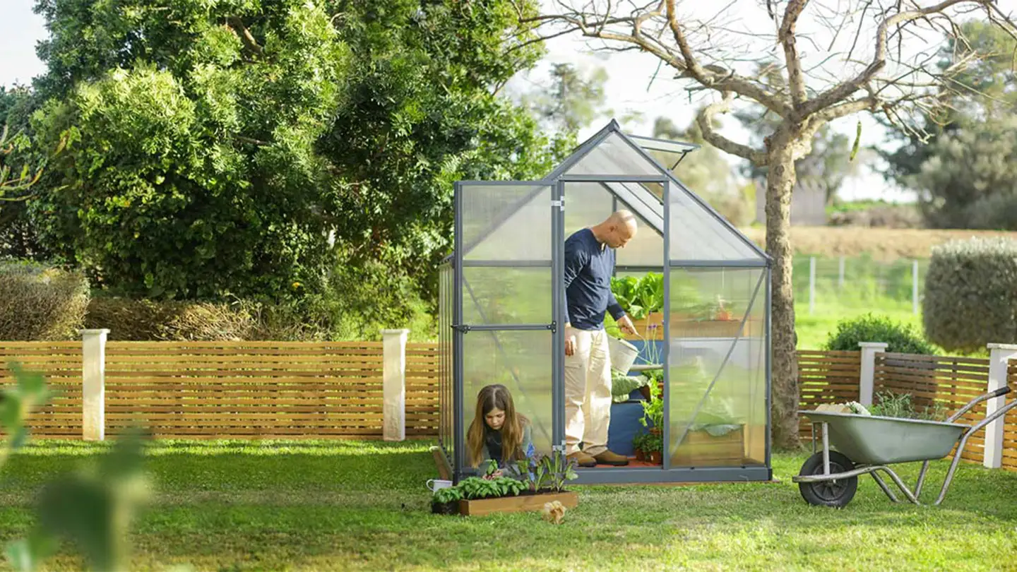 Canopia drivhus i hage med far og datter som planter